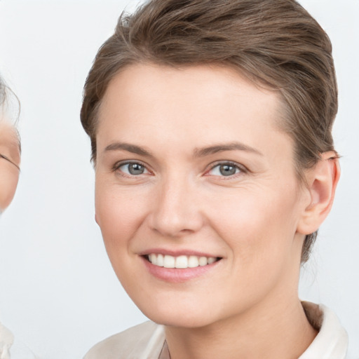 Joyful white young-adult female with short  brown hair and grey eyes