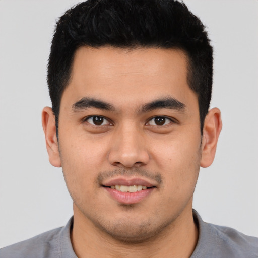 Joyful white young-adult male with short  black hair and brown eyes