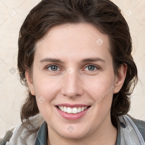 Joyful white young-adult female with medium  brown hair and grey eyes