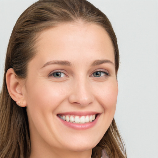 Joyful white young-adult female with long  brown hair and blue eyes