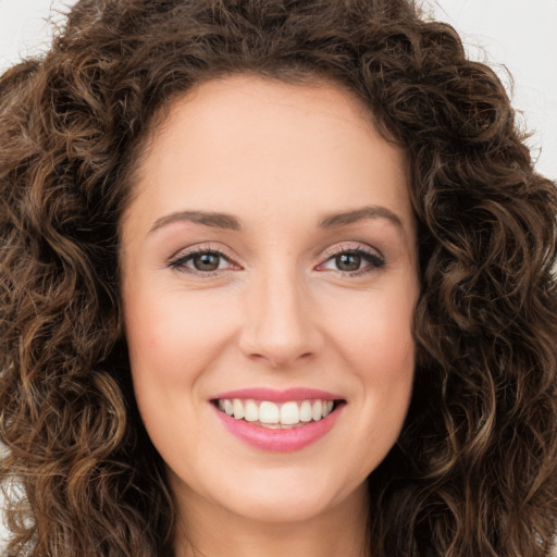 Joyful white young-adult female with long  brown hair and green eyes