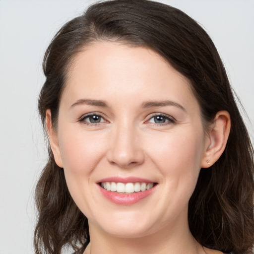 Joyful white young-adult female with long  brown hair and grey eyes