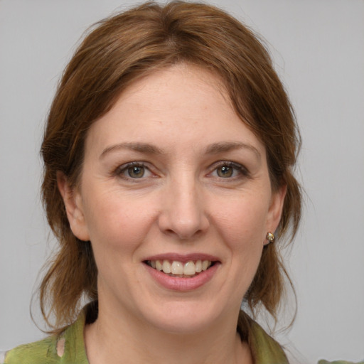 Joyful white young-adult female with medium  brown hair and grey eyes