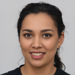 Joyful latino young-adult female with medium  brown hair and brown eyes