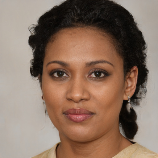 Joyful black young-adult female with medium  brown hair and brown eyes