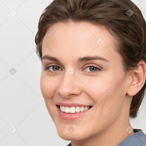 Joyful white young-adult female with medium  brown hair and grey eyes