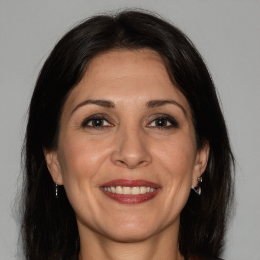 Joyful white adult female with long  brown hair and brown eyes