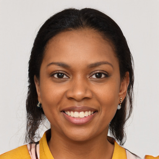 Joyful black young-adult female with long  brown hair and brown eyes