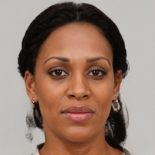 Joyful black adult female with medium  brown hair and brown eyes