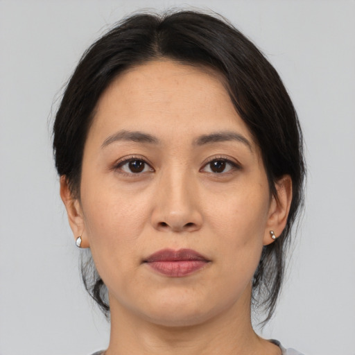 Joyful asian adult female with medium  brown hair and brown eyes