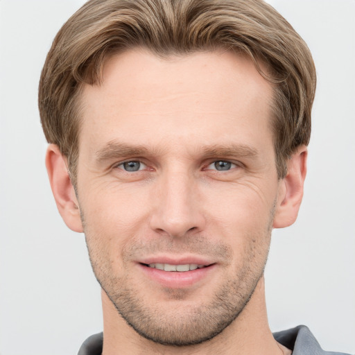 Joyful white young-adult male with short  brown hair and grey eyes