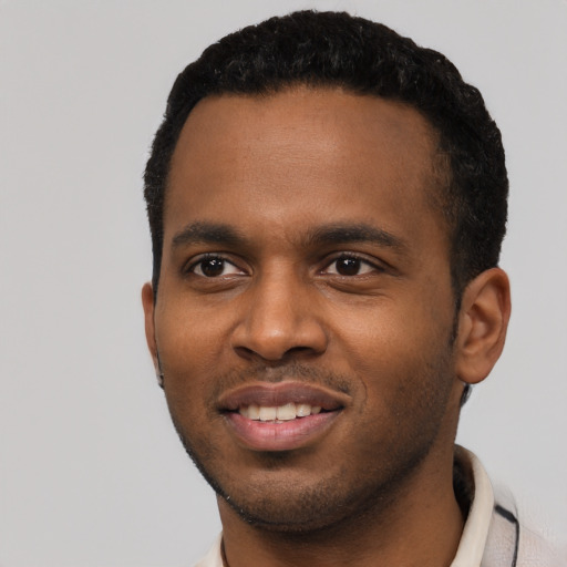 Joyful black young-adult male with short  black hair and brown eyes