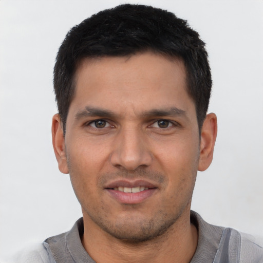 Joyful asian young-adult male with short  brown hair and brown eyes