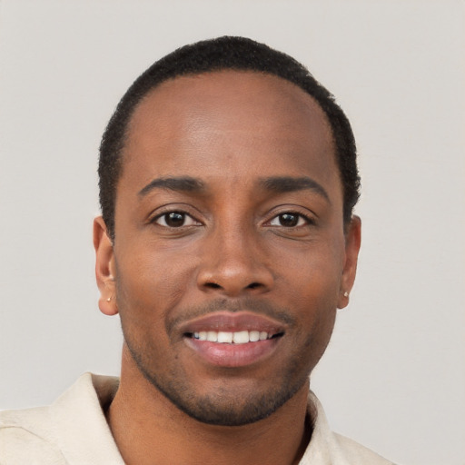 Joyful black young-adult male with short  brown hair and brown eyes