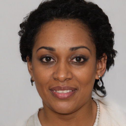 Joyful black young-adult female with short  black hair and brown eyes