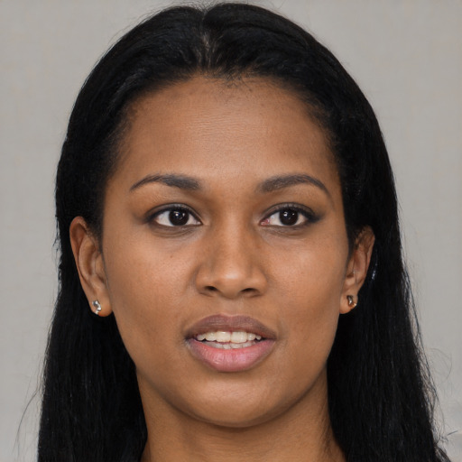 Joyful black young-adult female with long  black hair and brown eyes
