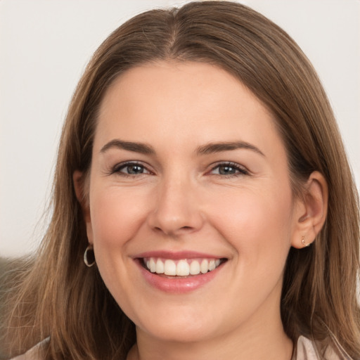 Joyful white young-adult female with long  brown hair and brown eyes