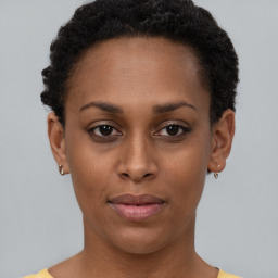 Joyful black young-adult female with short  brown hair and brown eyes