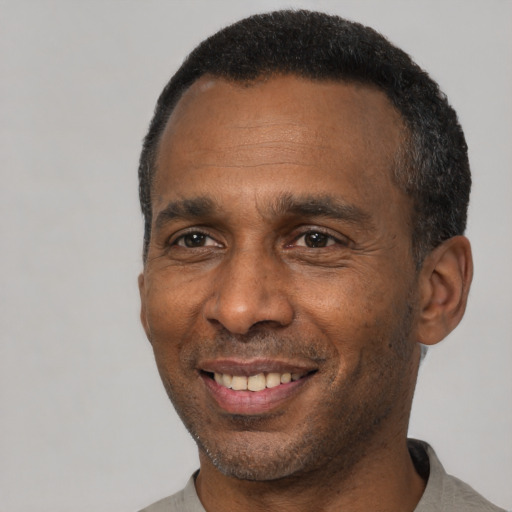 Joyful black adult male with short  black hair and brown eyes