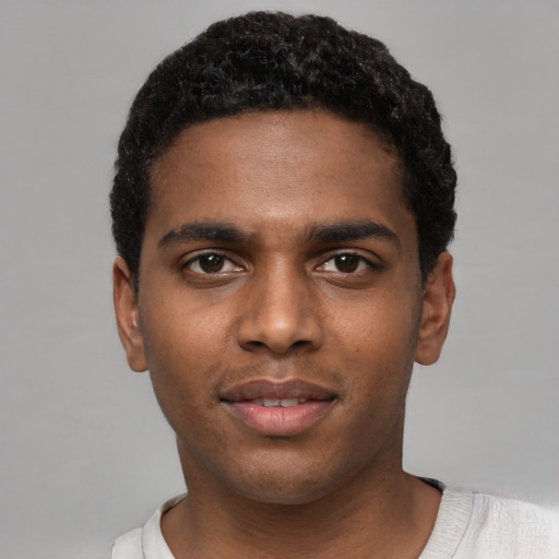Joyful black young-adult male with short  black hair and brown eyes