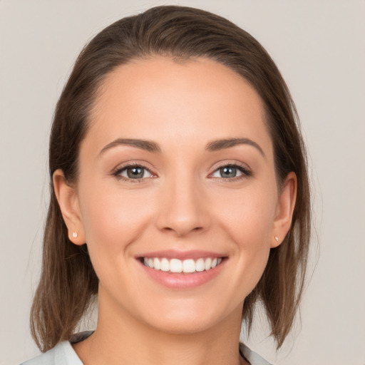 Joyful white young-adult female with medium  brown hair and grey eyes