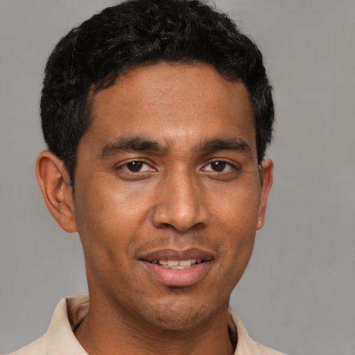 Joyful latino young-adult male with short  black hair and brown eyes