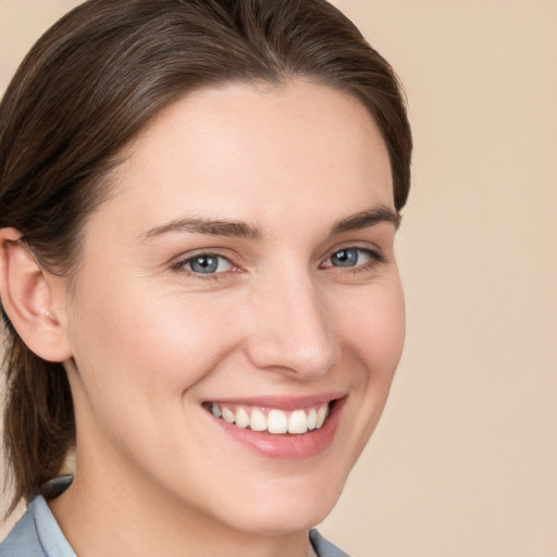 Joyful white young-adult female with medium  brown hair and grey eyes