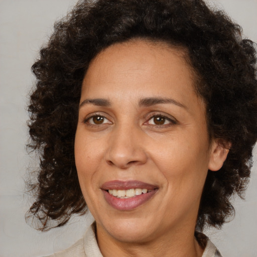Joyful black adult female with medium  brown hair and brown eyes