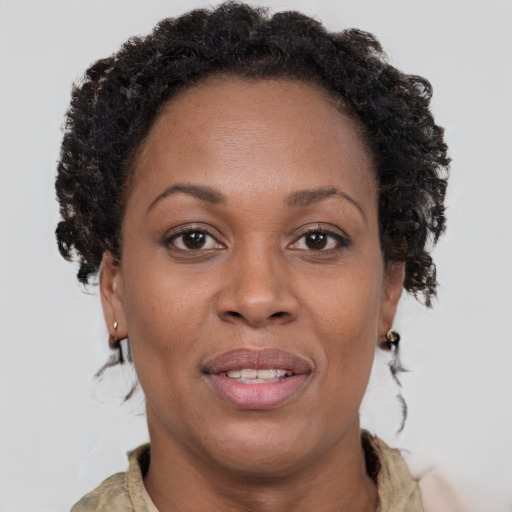 Joyful black adult female with medium  brown hair and brown eyes