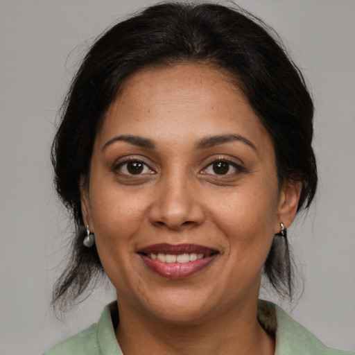 Joyful latino adult female with medium  brown hair and brown eyes