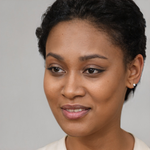 Joyful black young-adult female with short  brown hair and brown eyes
