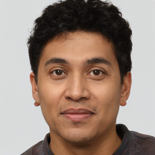 Joyful latino young-adult male with short  brown hair and brown eyes