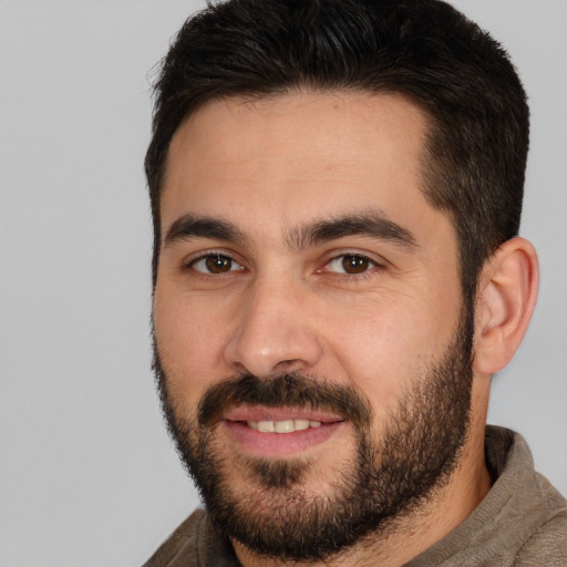 Joyful white young-adult male with short  black hair and brown eyes