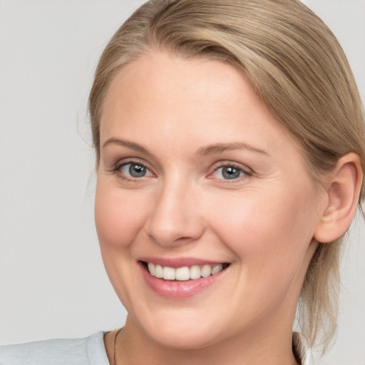 Joyful white young-adult female with medium  brown hair and blue eyes