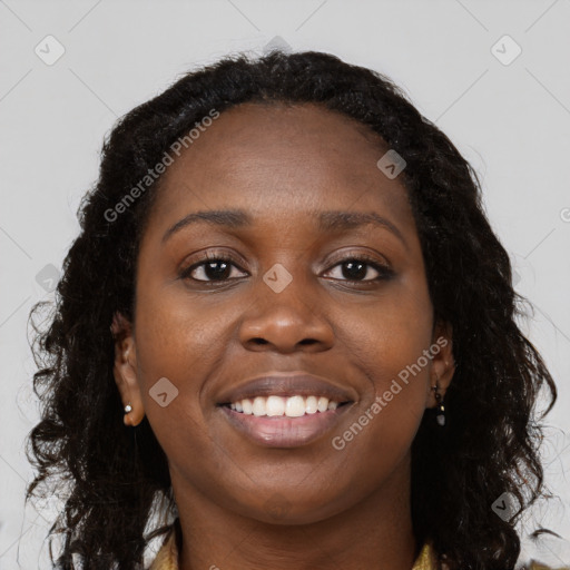 Joyful black young-adult female with long  brown hair and brown eyes