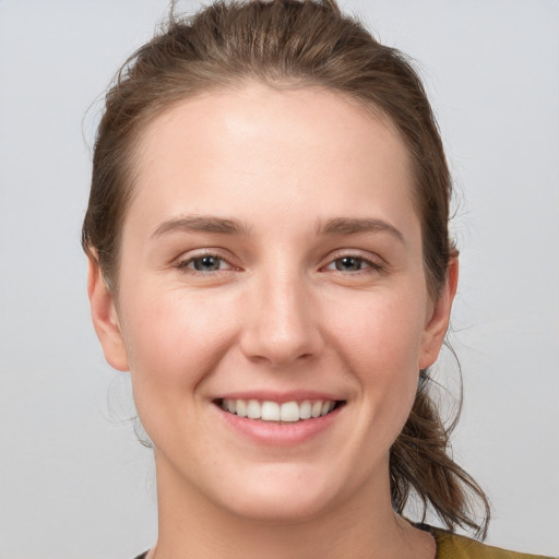 Joyful white young-adult female with medium  brown hair and grey eyes