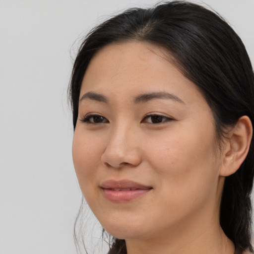 Joyful asian young-adult female with long  brown hair and brown eyes