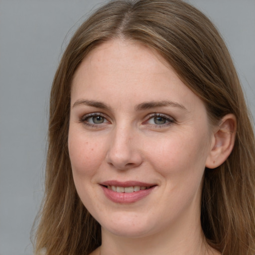 Joyful white young-adult female with long  brown hair and blue eyes