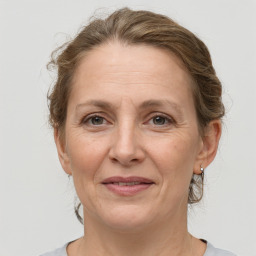 Joyful white adult female with medium  brown hair and grey eyes