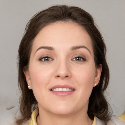 Joyful white young-adult female with medium  brown hair and grey eyes