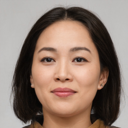 Joyful asian young-adult female with medium  brown hair and brown eyes