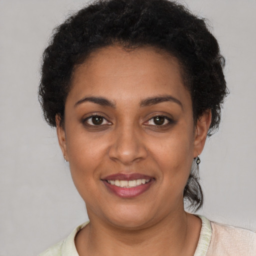 Joyful black young-adult female with short  brown hair and brown eyes