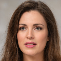 Joyful white young-adult female with long  brown hair and green eyes