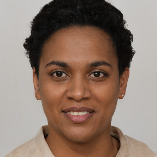 Joyful black young-adult female with short  black hair and brown eyes