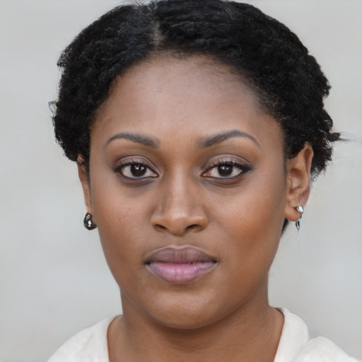 Joyful black young-adult female with short  brown hair and brown eyes