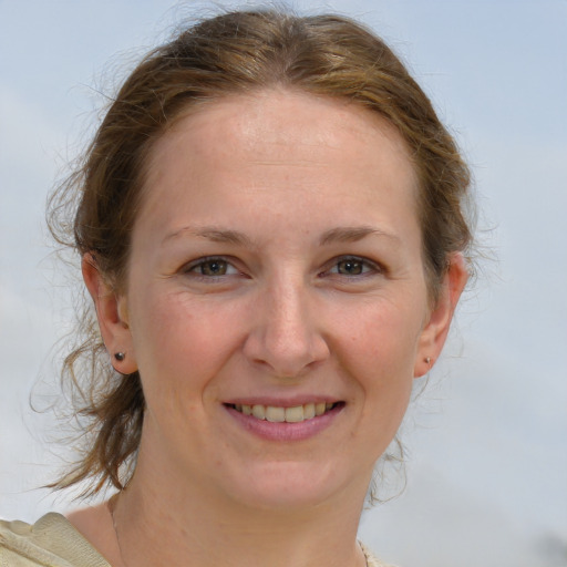 Joyful white young-adult female with medium  brown hair and grey eyes