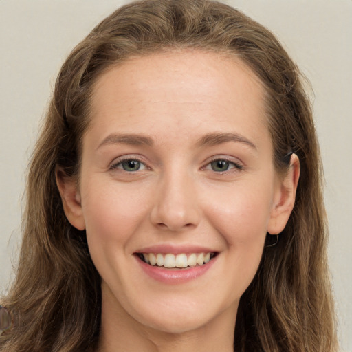 Joyful white young-adult female with long  brown hair and green eyes