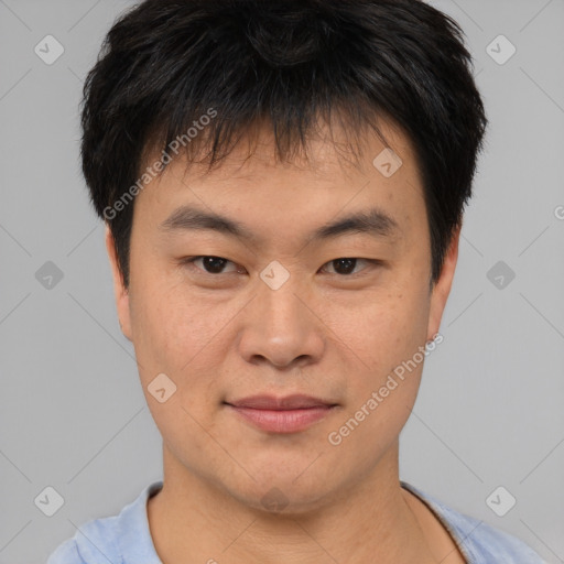 Joyful asian young-adult male with short  brown hair and brown eyes