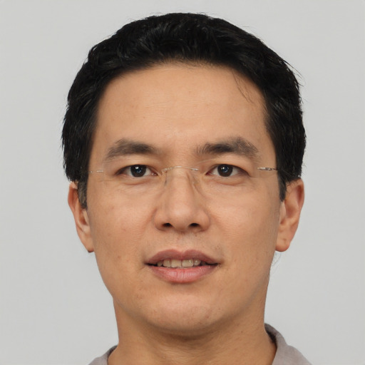 Joyful asian adult male with short  black hair and brown eyes