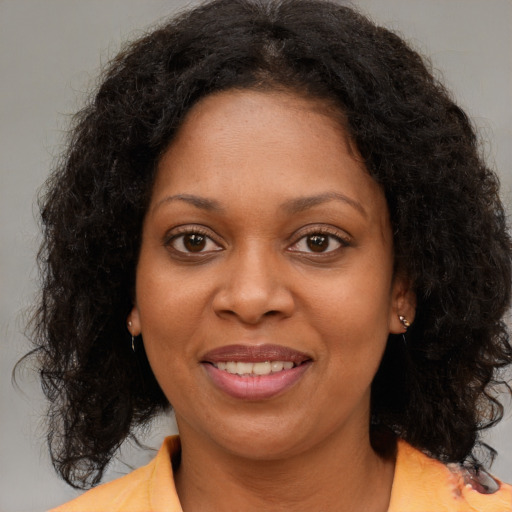 Joyful black young-adult female with medium  brown hair and brown eyes